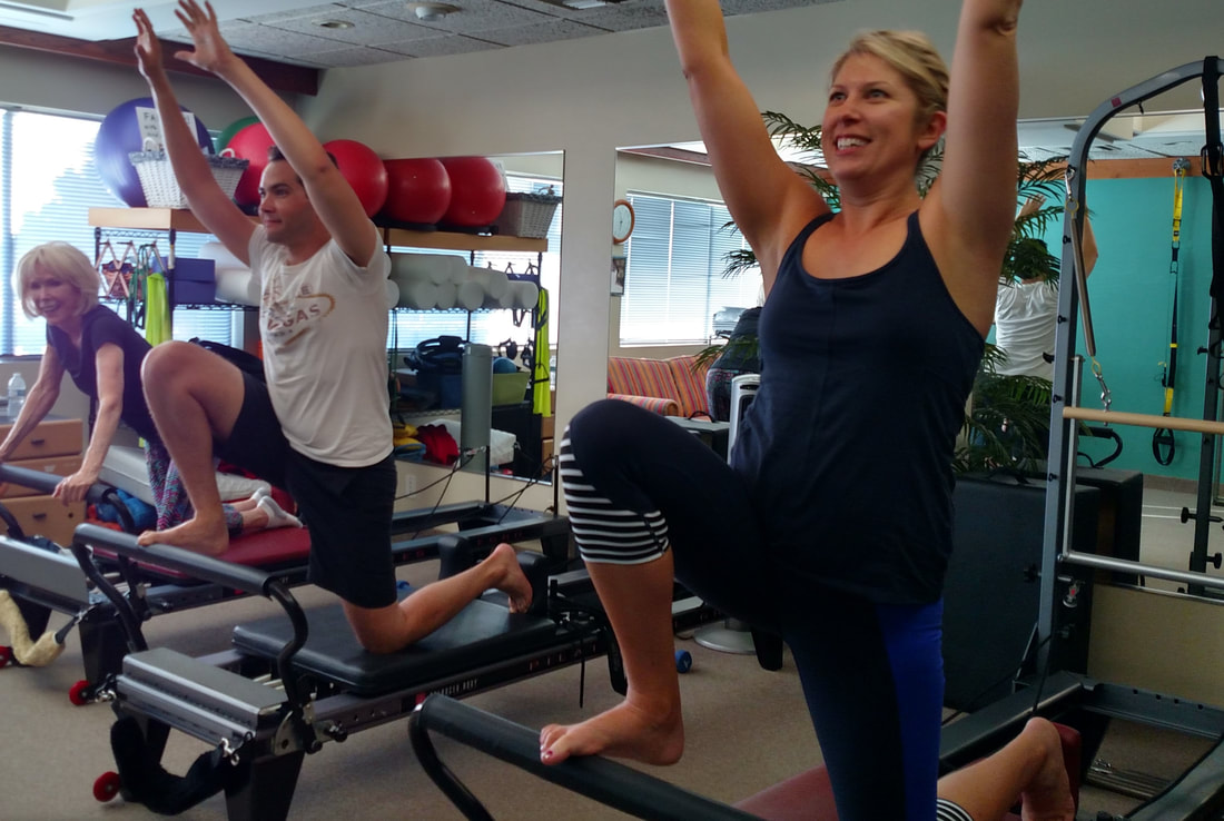3 people using the Pilates reformer